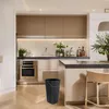 A modern kitchen with a black trash can in the foreground. Anteprima dell’immagine prodotto