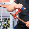 A person is using a pipe cutter on a copper pipe. Produktbild-Vorschau