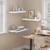 A corner of a room showing a desk and wall-mounted shelves with decor. Produktbild-Vorschau
