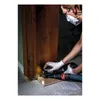 A person is using a sander to work on a wooden door frame. Voir les images du produit