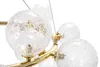 A close-up view of a modern chandelier with multiple glass globes and gold accents. Náhľad obrázku produktu