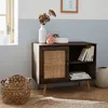 A wooden cabinet with a rattan door and a few decorative items on top. Anteprima dell’immagine prodotto