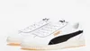 A pair of white Puma Club 5V5 sneakers with black accents and gold Puma branding, displayed against a white background. Náhled obrázku produktu