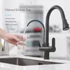 A hand is filling a glass with filtered water from a black kitchen tap. Náhľad obrázku produktu