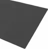 A close-up view of a dark gray mat, showing its texture and stitching. Voir les images du produit