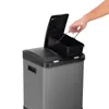 A hand is shown removing a black inner bin from a gray dual-compartment trash can. Produktbild-Vorschau