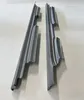 Two gray metal car parts are laid out on a light gray surface. Náhľad obrázku produktu