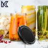 A close-up shot of several jars of pickled vegetables, with a black lid in the foreground. Voir les images du produit
