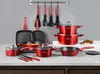 A collection of red cookware and kitchen utensils displayed on a countertop against a gray wall. Podgląd zdjęcia produktu