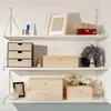 Several wooden boxes and decorative items are displayed on white shelves against a white wall. Náhled obrázku produktu