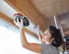 A woman is sanding a wooden beam near a window. Anteprima dell’immagine prodotto