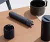 A cordless precision screwdriver and its accessories are arranged on a wooden desk next to a mug of coffee. Voir les images du produit