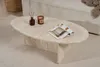 A travertine coffee table with a magazine, candle, and diffuser on it, placed on a rug next to a sofa. Anteprima dell’immagine prodotto