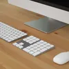 A close-up view of a computer keyboard, numeric keypad, trackpad, and mouse on a wooden desk. Náhled obrázku produktu
