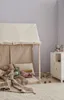 A child's play tent filled with stuffed animals and blankets, set up in a room with a white cabinet and a wooden toy. Produktbild-Vorschau
