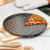 A slice of pizza sits on a perforated pizza pan, which is placed on a wooden cutting board. Wooden spoons are in the foreground, and an oven mitt is in the background. Náhľad obrázku produktu