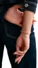 A close-up shot of a person's wrist wearing a bracelet with charms. Produktbild-Vorschau