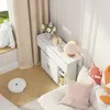 A corner of a room decorated with children's items, featuring a white foldable table, stuffed animals, and cushions. Voir les images du produit
