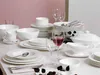 A formal table setting with a complete dinnerware set, including plates, bowls, cups, glasses with red wine, and serving dishes. Náhled obrázku produktu