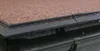 A close-up view of a roof edge with a gutter system and water dripping. Produktbild-Vorschau