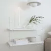 A white wall-mounted shelf with decorative items. Produktbild-Vorschau