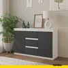 A modern sideboard with dark gray doors and white accents, decorated with a lamp, framed picture, and decorative bottles, next to a potted plant. Náhľad obrázku produktu