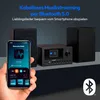 A hand holding a smartphone displaying a radio app, with a MEDION micro audio system and speakers in the background, connected via Bluetooth. Produktbild-Vorschau