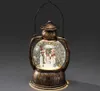 A decorative snow globe lantern with a snowman family inside. Produktbild-Vorschau