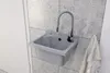 A grey sink with a flexible faucet is mounted on a tiled wall, with a white towel hanging to the right. Anteprima dell’immagine prodotto