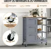 A grey kitchen cart with a wooden top, featuring drawers and shelves, is shown in a room. The image includes close-up diagrams highlighting the wheels and their locking mechanism. Voir les images du produit