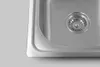 A close-up view of a stainless steel sink with a drain. Produktbild-Vorschau