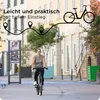 A woman is riding a bicycle on a street in front of buildings and trees. There is a graphic overlay with text and a bicycle illustration. Produktbild-Vorschau