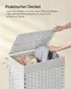 A person's hands are shown placing laundry into a white woven laundry basket with a lid. Produktbild-Vorschau