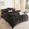 A bedroom scene with a bed covered in dark gray plush bedding. Anteprima dell’immagine prodotto