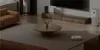 A modern living room with a sofa, coffee table, and a robot vacuum cleaner. Náhľad obrázku produktu