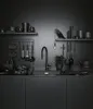 A dark, moody kitchen scene with a black faucet as the central element. Podgląd zdjęcia produktu