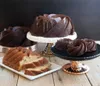 A collection of bundt cakes and mini bundt cakes arranged on cake stands on a wooden surface. Podgląd zdjęcia produktu