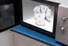 A heat pack with star patterns is placed inside an open microwave. Produktbild-Vorschau