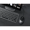 A computer mouse and keyboard are placed on a dark gray surface next to a computer monitor. Produktbild-Vorschau