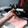 A close-up of a person's hand receiving a manicure, with a pink nail dust collector in the foreground. Anteprima dell’immagine prodotto