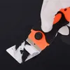 A gloved hand is using a scraper to remove white residue from a dark surface. Náhled obrázku produktu