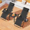 Two black zero gravity chairs with a small table between them on a wooden deck. Produktbild-Vorschau