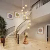 A grand staircase in a modern home, illuminated by a cascading chandelier. Podgląd zdjęcia produktu