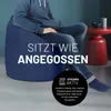 A person sitting on a blue beanbag chair. There is text overlaying the image. Náhled obrázku produktu