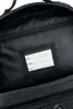 Close-up view of the inside of a black backpack, showing a label for name, address, and phone number. Náhled obrázku produktu