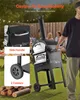 A man is pushing a pizza oven outdoors, with people in the background enjoying a meal. Produktbild-Vorschau