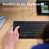 A hand is typing on a black wireless keyboard, with a laptop and tablet in the background. Anteprima dell’immagine prodotto
