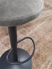 A close-up view of a gray bar stool with a black base and footrest, resting on a textured brown rug. Produktbild-Vorschau