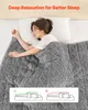 A woman sleeping comfortably under a weighted blanket on a bed. Anteprima dell’immagine prodotto