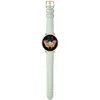 A smartwatch with a green band and gold casing is displayed against a white background. Voir les images du produit